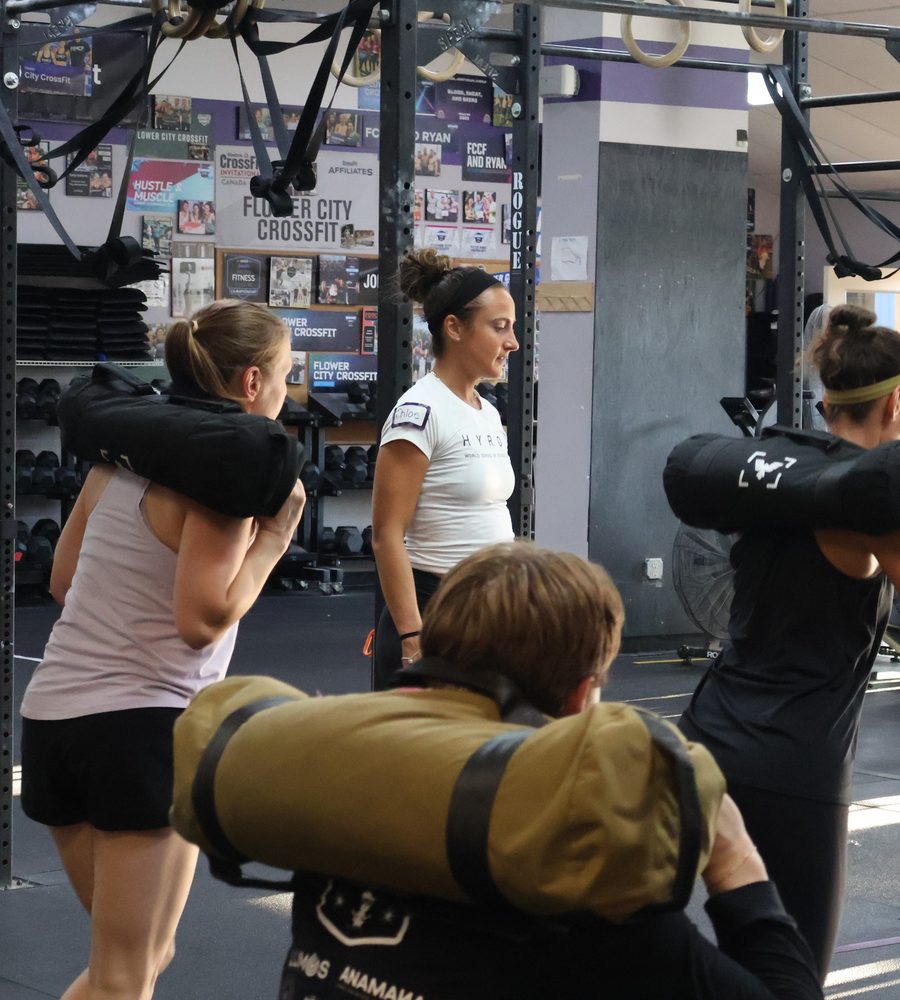 Members working through sandbag lunges side by side