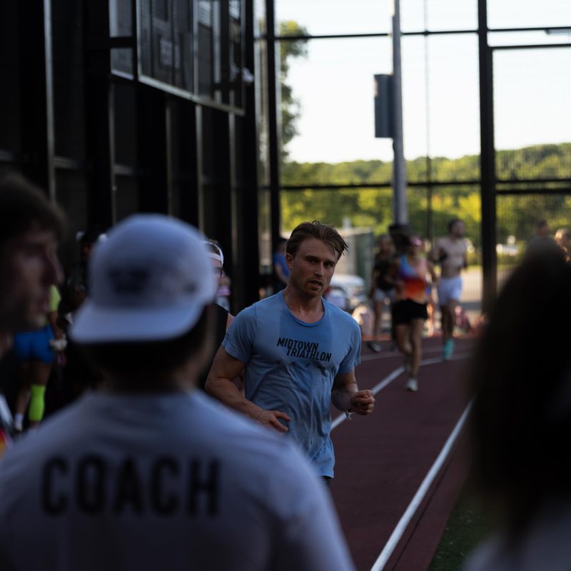 A coach watching an athlete come around the track
