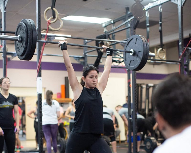A member locking out a barbell overhead