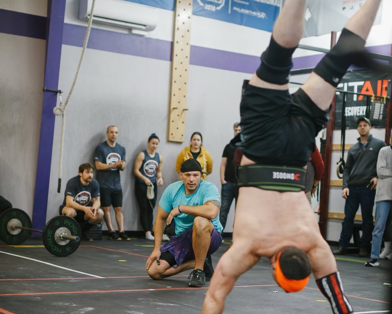 Members cheering on a handstand walk during a competition